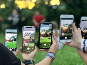 People Holding Smartphones while Taking Photos