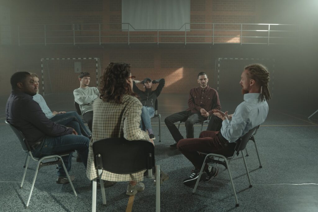 People Sitting on Chairs Inside a Gymnasium